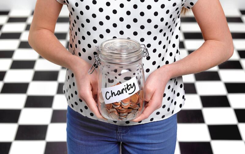 Twelve year old with collected charity donations in jar. Getty Images
