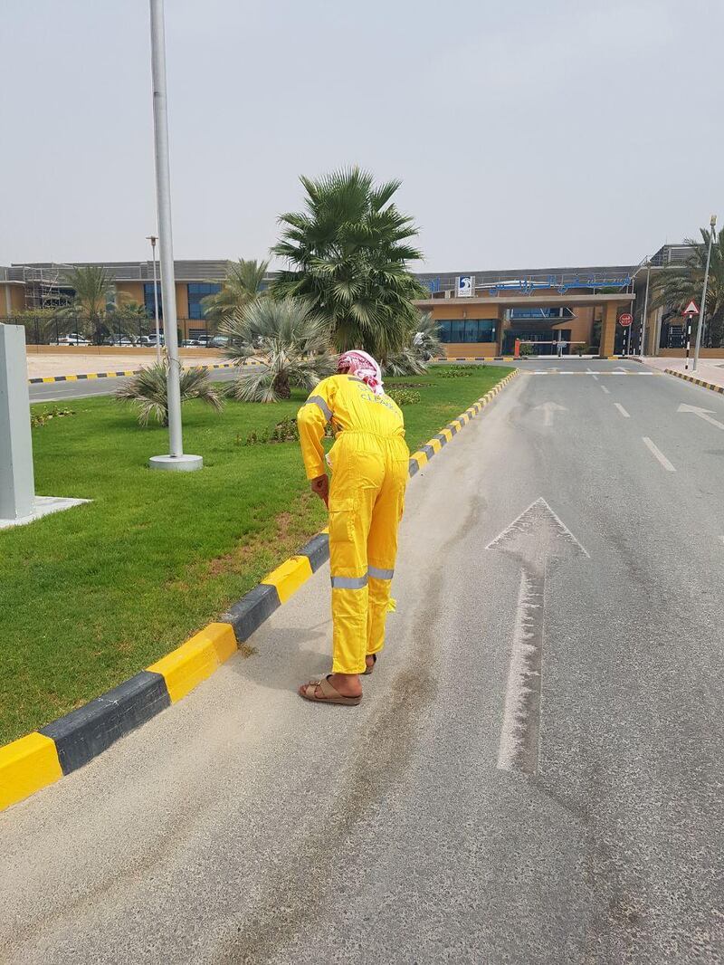 A man sentenced to community service in Al Dhafra sweeps the street.
