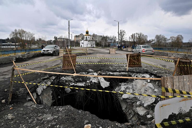 The Russian offensive in the Kyiv region has left a huge crater on a bridge in Makariv. AFP