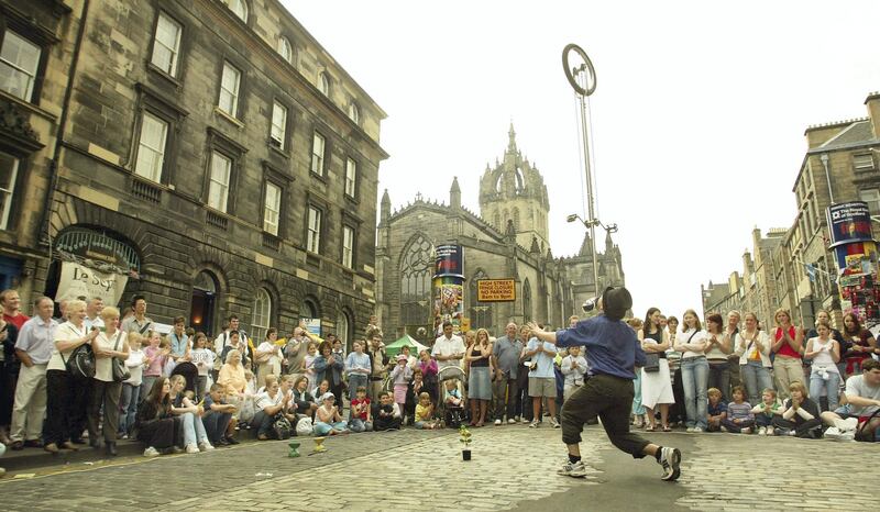 EDINBURGH, SCOTLAND - AUGUST 5:  A street performer balances a unicycle on his face while entertaining the crowd during the 57th Edinburgh Festival Fringe 2003 August 5, 2003 in Edinburgh, Scotland. The festival is the world's largest celebration of the arts, with a mix of cultural and artistic expression. The festival is open to all performers, with no selection process, resulting in approximately 20,000 individual performances.  (Photo by Scott Barbour/Getty Images)