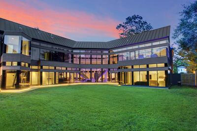 In contrast to the front of the house, the back consists of floor-to-ceiling glass. Courtesy Martha Turner Sotheby's International Realty