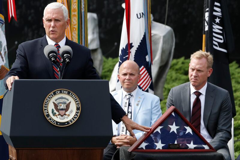 Vice President Mike Pence, left, gestures to an American flag that was used during the return of remains from the Korean War in Hawaii in August 2018, while presenting it to the Korean War Veterans Memorial Foundation, Thursday, Sept. 20, 2018, during a ceremony at the Korean War Veterans Memorial in Washington. At center is Richard Dean, Vice Chairman of the Korean War Veterans Memorial Foundation, and right is Deputy Secretary of Defense Patrick Shanahan. (AP Photo/Jacquelyn Martin)