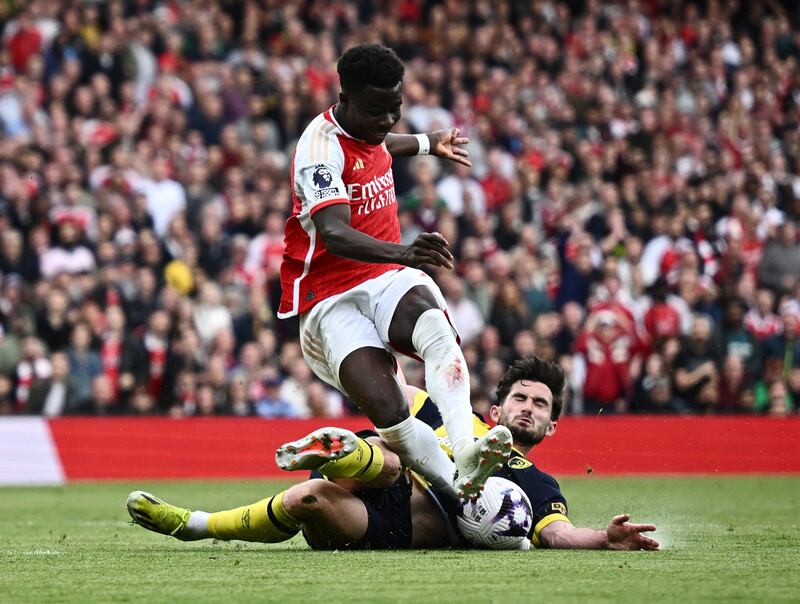 Bournemouth's Lewis Cook makes a superb last-ditch tackle to deny Bukayo Saka a shot on goal for Arsenal. Reuters
