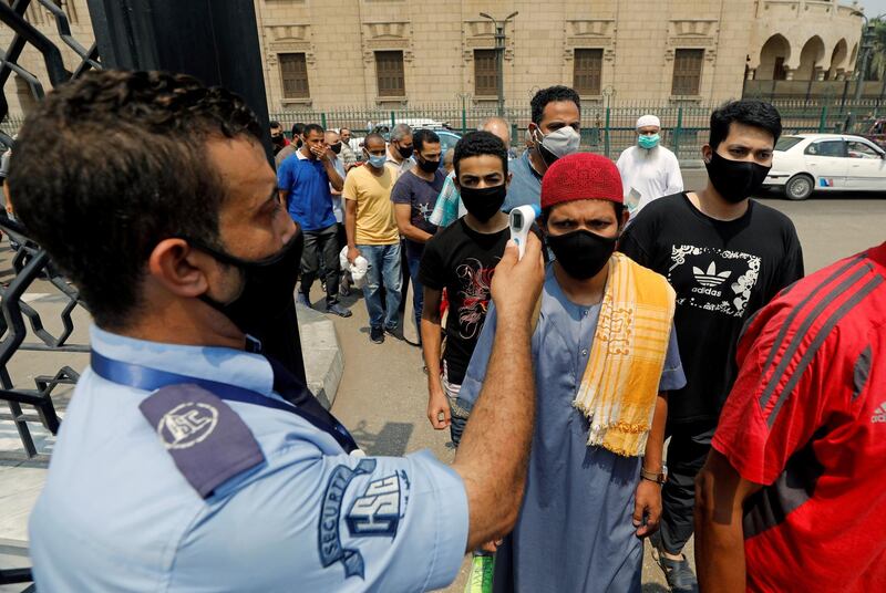 A security guard checks the temperature of worshippers before they enter the Al Azhar mosque. Reuters
