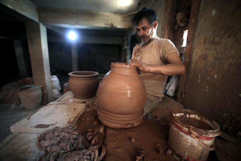 An Egyptian potter shapes a clay ornament.