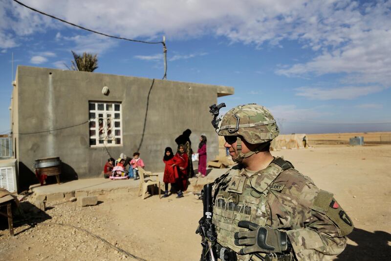 In this Jan. 27, 2018, photo, U.S. Army soldiers speak to families in rural Anbar on a reconnaissance patrol near a coalition outpost in western Iraq. A few hundred American troops are stationed at a small outpost near the town of Qaim along Iraq's border with Syria. Thousands of U.S. troops and billions of dollars spent by Washington helped bring down the Islamic State group in Iraq, but many of the divisions and problems that helped fuel the extremistsâ€™ rise remain. (AP Photo/Susannah George)