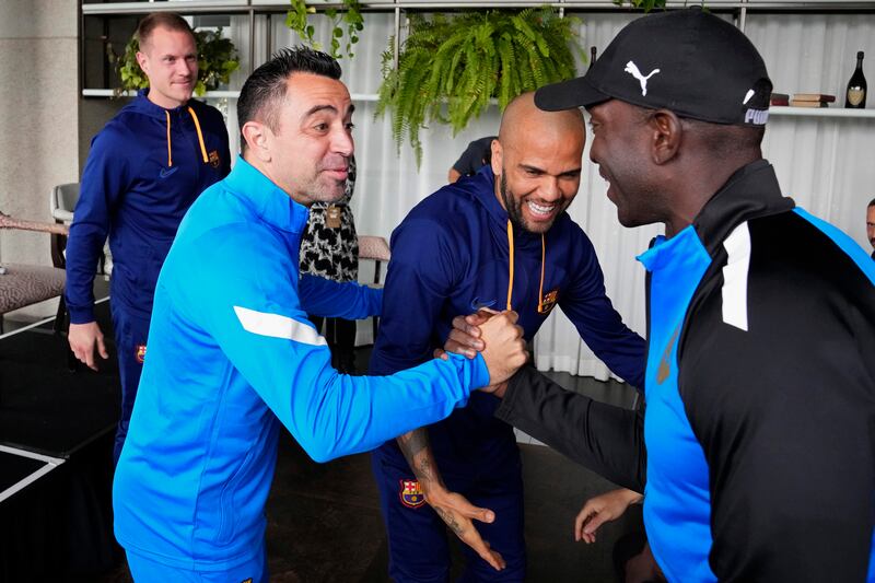 FC Barcelona manager Xavi Hernandez, second left, and players Marc-Andre ter Stegen, left, and Dani Alves meet the A-League All Stars' manager Dwight Yorke, right, during a press conference in Sydney, Australia, Tuesday, May 24, 2022, ahead of a friendly soccer match between Barcelona and the All Stars on Wednesday.  (AP Photo / Rick Rycroft)