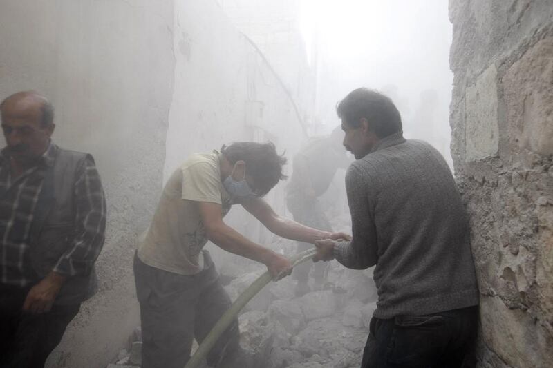 Men try to put out fire at a site hit by what activists said was an air strike by forces loyal to Syria's President Bashar Al Assad in the town of Azaz, north of Aleppo, near the border with Turkey, on May 5, 2014. Mahmoud Hassano / Reuters