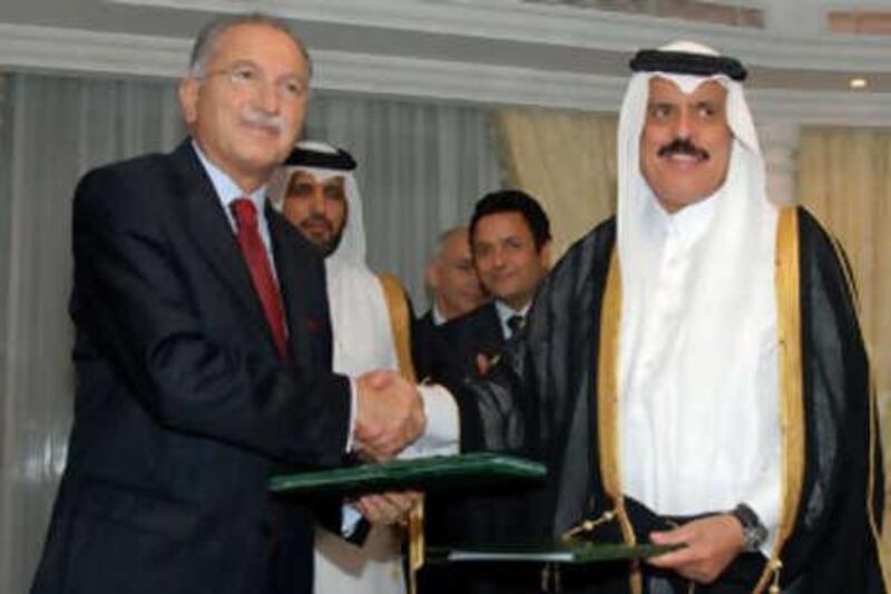 Ekmeleddin Ihsanoglu, secretary general of the OIC, left, shakes hands with Abdul Rahman al Attiyah, secretary general of GCC, after signing an agreement to improve political, social and financial relations in the Saudi city of Jeddah.