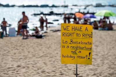Picture shows a protest-placard on La Barceloneta beach during a demonstration against "drunken tourism" called by the residents of La Barceloneta neighbourhood in Barcelona, on August 12, 2017.    / AFP PHOTO / Josep LAGO