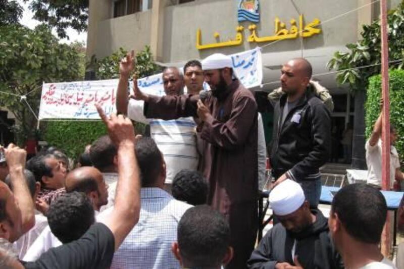 epa02694747 An Islamic Salafist cleric (C) addresses protesters gathering in front of the Qina province headquarters (background), southern Egypt, to protest against the appointment of a new Coptic Christian governor, in Qina, southern Egypt, 19 April 2011. According to media sources, thousands of conservative Muslims started protests on 15 April. Witnesses said the protesters, mostly observers of the conservative Islamic Salafist movement, threatened to bar Emad Mikhail, the new governor, from entering the province. The previous governor, whom Mikhail will replace, was also Christian. Qina has seen sectarian strife in the past, with the latest in the series occurred late last year, when dozens of Christians and Muslims were arrested after nearly a dozen homes were burnt in clashes between members of the two religions.  EPA/STR *** Local Caption ***  02694747.jpg