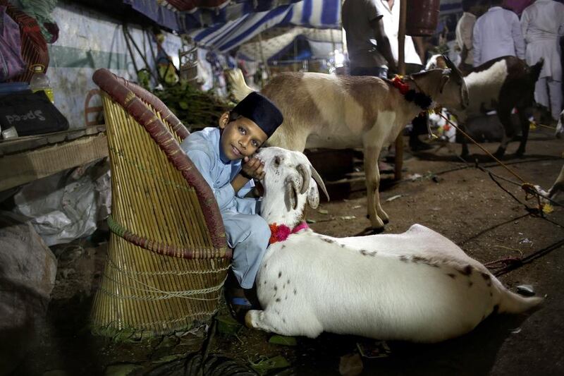 A young vendor caresses a goat as he awaits customers at a market ahead of the Muslim festival Eid Al Adha, in New Delhi, India. Altaf Qadri / AP Photo