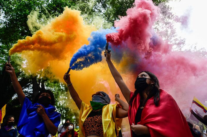 Activists in Mexico City with flares in the colour of the Colombian flag during a protest in solidarity with Colombian women and against Colombian President Ivan Duque's government. AFP