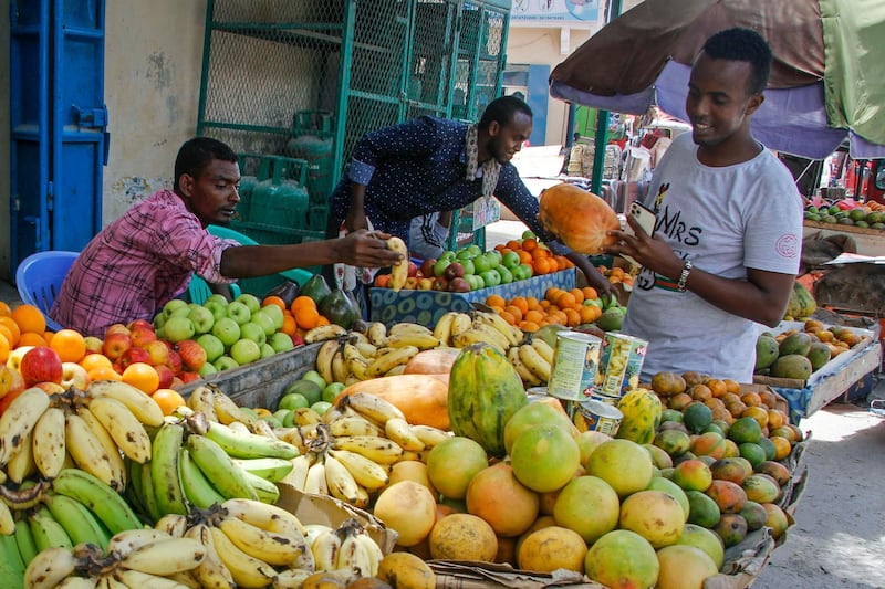 A customer examines fruit for sale in a street-market as families shop for the Muslim holiday of Eid al-Fitr, which marks the end of the holy fasting month of Ramadan, in Mogadishu, Somalia. AP