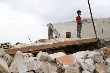 A Syrian boy stands above the rubble of a building in the village of Rabaa Jour in the largely militant-held Syrian province of Idlib on May 6, 2019. AFP
