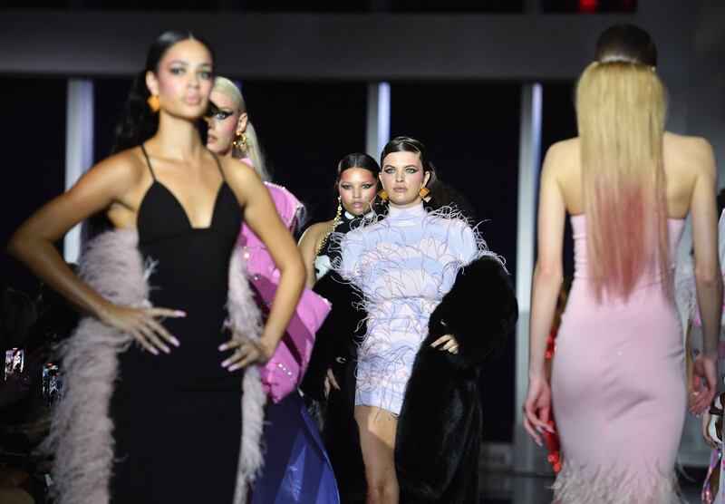 Feathers in pink adorned sleeves and bandeau tops, and trains trailed behind some of his models as they camped it up for the cameras at Christian Cowan. AFP