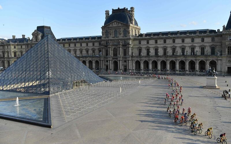 Colombia's Egan Bernal, second right, wearing the overall leader's yellow jersey, passes by the Louvre in Paris on July 28, 2019. AFP