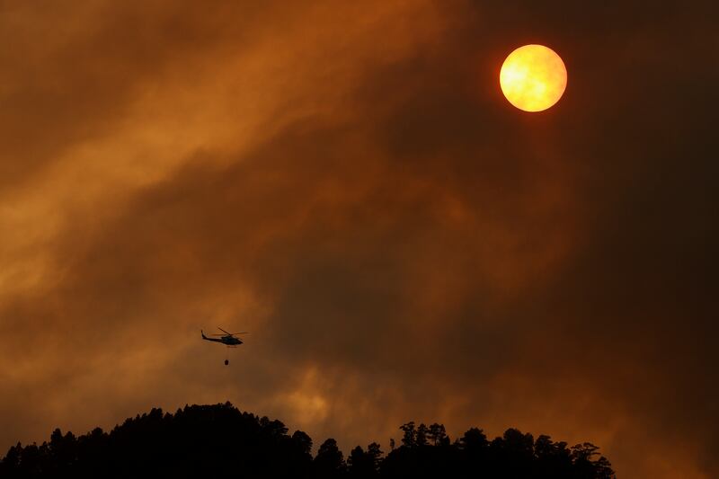 A helicopter dumps water on a fire in Candelaria. Reuters