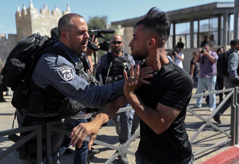 An Israeli police officer and a Palestinian man scuffle during clashes that erupted ahead of a planned march by Jewish ultranationalists through east Jerusalem, outside Jerusalem's Old City. AP