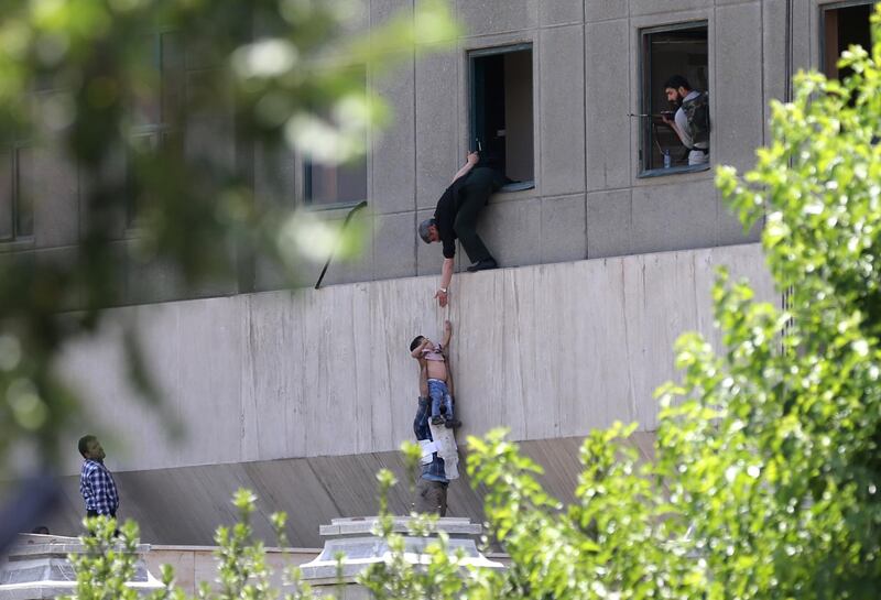 Iranian policemen evacuate a child from the parliament building in Tehran on June 7, 2017 during an attack on the complex. 


The Islamic State group claimed its first attacks in Iran as gunmen and suicide bombers killed at least five people in twin assaults on parliament and the tomb of the country's revolutionary founder in Tehran. / AFP PHOTO / FARS NEWS / OMID VAHABZADEH