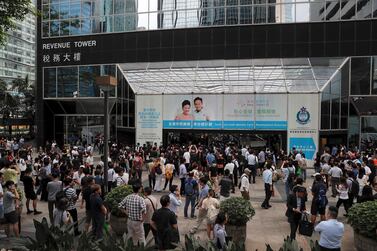 People watch protesters gather at the main entrance of the Hong Kong Revenue Tower in Hong Kong on Monday. AP