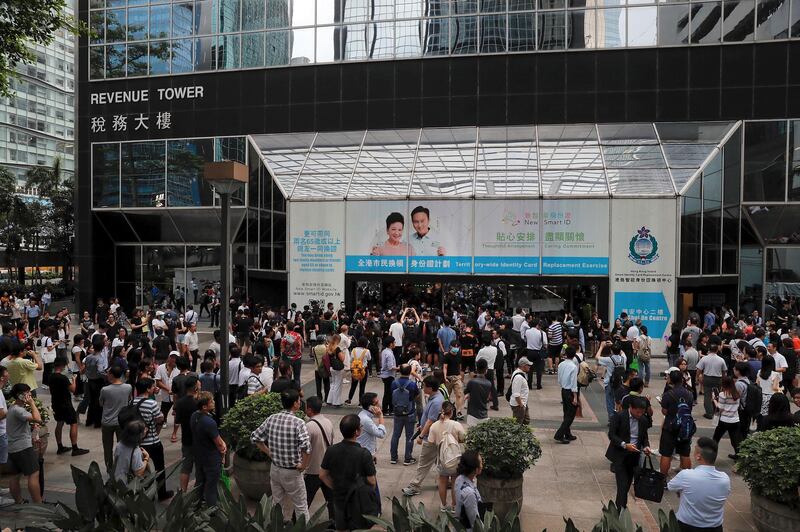 People watch protesters gather at the main entrance of the Hong Kong Revenue Tower in Hong Kong on Monday, June 24, 2019. Mass protests in recent weeks have occurred in Hong Kong over legislation that was seen as increasing Beijing's control and over police treatment of the protesters. (AP Photo/Kin Cheung)