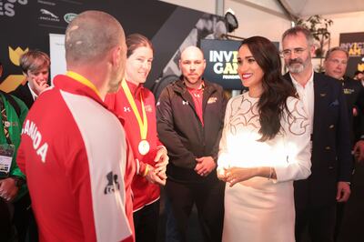 Meghan, Duchess of Sussex, wears a white Valentino dress as she chats with members of the Canadian Invictus Team. Getty Images