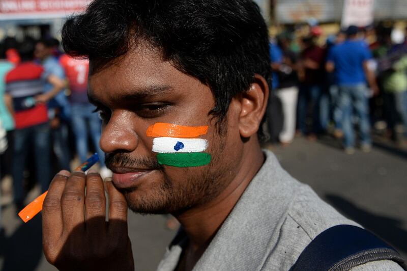 A fan of the Indian cricket team gets tri-colours painted on his face before the second Test between India and England outside the M.A. Chidambaram Cricket Stadium in Chennai. AFP