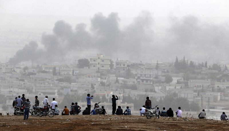 Turkish Kurds look at the ISIS-besieged Syrian town of Kobane from a hill near the border crossing, in the southeastern Turkish town of Suruc in Sanliurfa province in 2014. Umit Bektas / Reuters