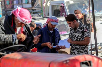 epaselect epa06906430 Lebanese security general officer inspect the paper of a Syrian refugee as he is evacuated from a refugees camp in the village of Arsal, east of Lebanon, 23 July 2018, to return home to their villages in al-Qalamoun area in the western Damascus countryside. According to media reports, Lebanon hosts 1,011,366 Syrian refugees registered with UNHCR, Including 80 thousand refugees living in seven camps in the city of Arsal. 850 person who have permission from the Syrian authority left to return home on 23 July 2018, where tousends of Syrian refugees families registers their names and wait the syrian permission.  EPA/NABIL MOUNZER