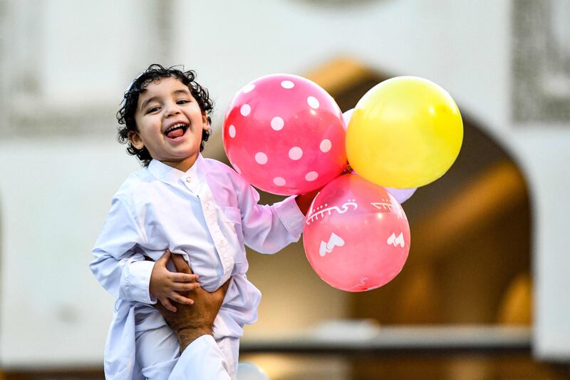 A boy holds balloons after the morning prayers for Eid Al Adha at the Azhar mosque in the centre of Cairo. AFP