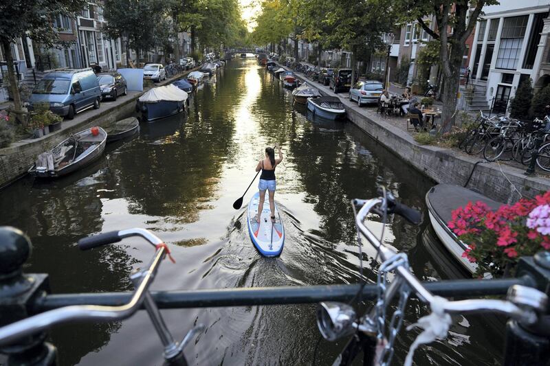 AMSTERDAM, NETHERLANDS - SEPTEMBER 21: A woman is padding on a canal on September 21, 2020 in Amsterdam, Netherlands. Due to the rapid rise in new Coronavirus cases, Dutch authorities have imposed a 1 a.m. curfew on bars and restaurants in Amsterdam and other major cities. The Netherlands has reported some 90,047 coronavirus cases, with 2000 new recorded cases in the last 24 hours.  (Photo by Pierre Crom/Getty Images)