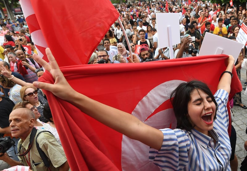 Tunisian women chant slogans as they wave their national flags during a demonstration to mark Tunisia's Women's Day and to demand equal inheritance rights between men and women on August 13, 2018, in the capital Tunis. - Tunisia's President Beji Caid Essebsi announced plans to submit a draft bill to parliament equalising inheritance rights between men and women. The proposal to equalise inheritance is among the most hotly debated of a raft of proposed social reforms, guided by a commission the president set up a year ago. (Photo by FETHI BELAID / AFP)