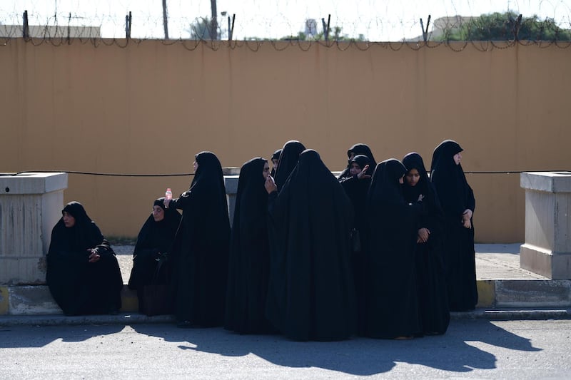 Women watch protesters and Iraqi Shiite militia supporters protesting outside the US embassy in Baghdad.  EPA