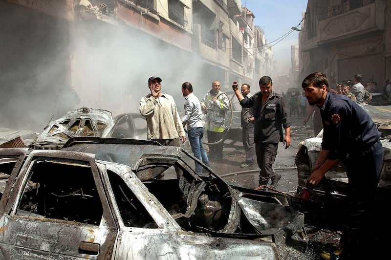 Syrian policemen and residents inspect the site of a car bombing in the government-held Abbasid neighbourhood of Homs that killed dozens of people on April 29, 2014. EPA 