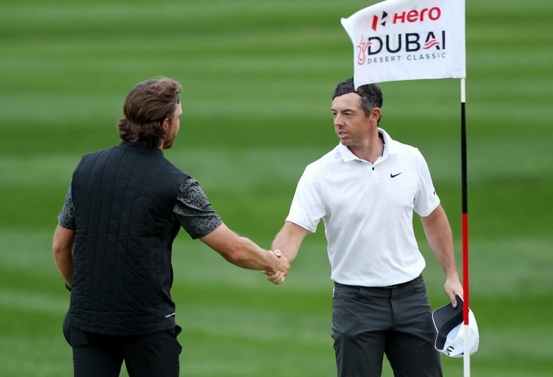Tommy Fleetwood and Rory McIlroy of Northern Ireland shake hands on the 7th green as play is suspended. Getty