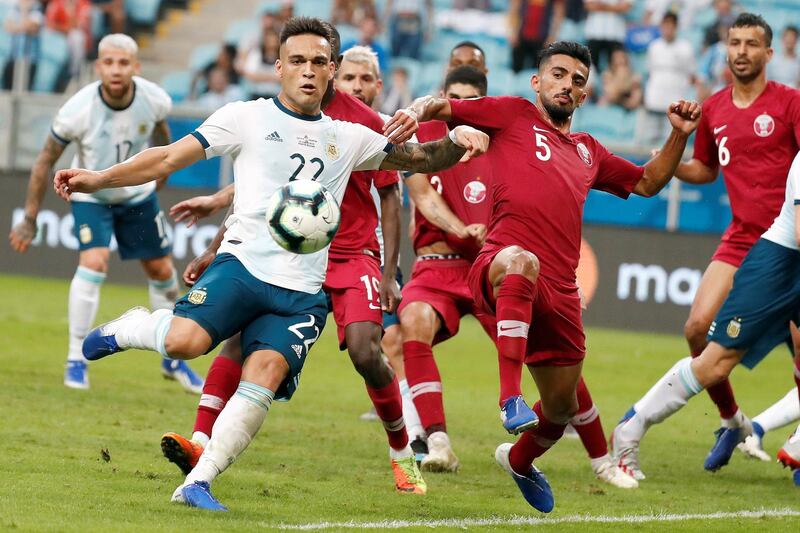 Argentina's Lautaro Martinez vies for the ball with Qatar's Tarek Salman. EPA
