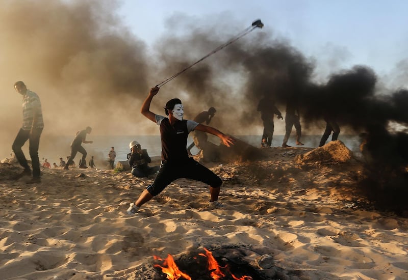 A Palestinian protester uses a slingshot to hurl stones during a demonstration on the beach near the maritime border with Israel, in Beit Lahia in the northern Gaza Strip. AFP