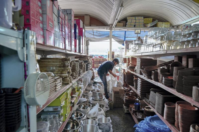 Abu Dhabi, United Arab Emirates, July 17, 2019.  Vendors of Al Mina Photo Project.  Al Mina Souk Market -- A kitchenware vendor arranges the stall before the days peak time which is from 6 p.m. to 9 p.m..  The Souk closes at 11 pm.
Victor Besa/The National
Section:  NA
Reporter: