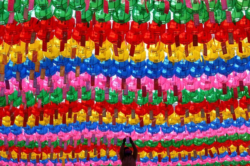 A worker attaches a name tag of a Buddhist who made donation to a lantern for Buddha's birthday at the Jogye temple in Seoul, South Korea. Ahn Young-joon / AP Photo