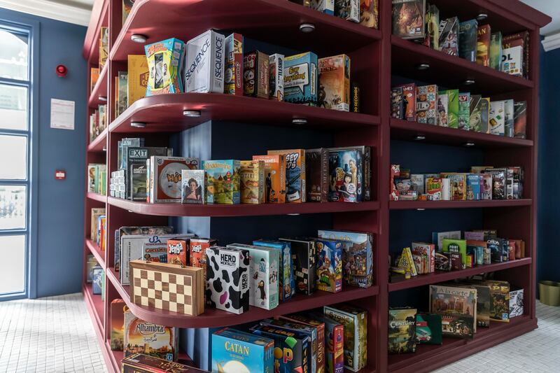 One corner of the cafe has a bookshelf filled with games.