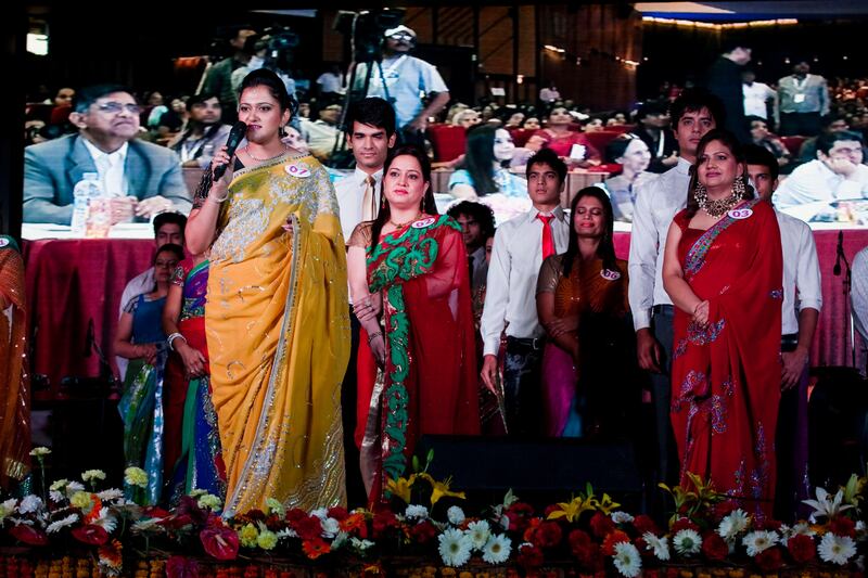 Winner Jyoti Nagpal (#2) stands behind 1st runner-up Nisha Sharma (#7, in yellow), 37, during the question and answer test at the semifinal round of the inaugural AAS Housewives Awards 2012 on 19th May 2012 in New Delhi, India. Out of 12 selected semi-finalists, 6 finalists will be chosen based on a question and answer session on stage, and other criteria such as poise. The winner, and 1st and 2nd runner-ups are Jyoti Nagpal (#2), Nisha Sharma (#7) and Seema Sharma (#4)respectively. The awards also served as a platform for Cervical Cancer Awareness. Photo by Suzanne Lee for The National