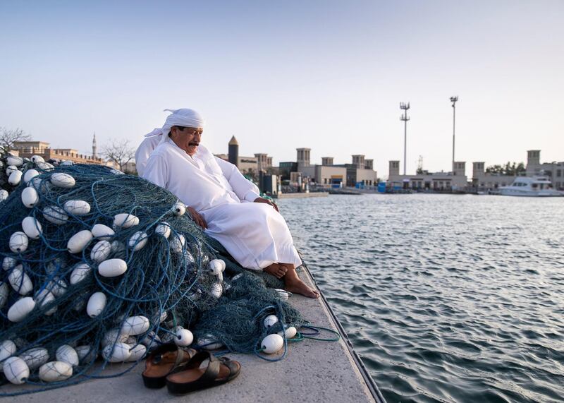 DUBAI, UNITED ARAB EMIRATES. 30 MARCH 2020. 
A fisherman takes a break with his friend at Jumeirah fishing harbour.

The Ministry of Agriculture and Fisheries has closed th fish markets.

(Photo: Reem Mohammed/The National)

Reporter:
Section: