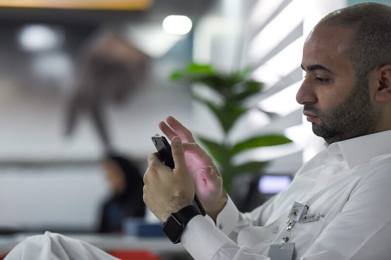 A picture taken on August 17, 2017 shows a Saudi employee checking his cell phone at his office in the capital Riyadh.
Initially conceived as a tool for soliciting bluntly frank workplace feedback, the app "Sarahah" (which means "Honesty" in Arabic) has found its way into the smart phones of millennials worldwide, even as critics have raised alarm about trolling and privacy issues.
The app, whose mass appeal stems from the appetite in the Arab world -- notorious for online censorship, has a frugal design and a simple prompt that encourages users to leave anonymous messages that do not allow the recipient to reply but only share on social media or block the sender. / AFP PHOTO / FAYEZ NURELDINE