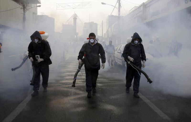 Firefighters disinfect streets in an effort to stop the spread of coronavirus in Tehran, March 13. EPA