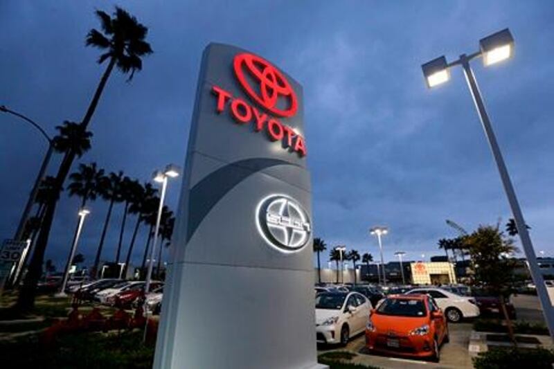 In this Thursday, Nov. 8, 2012, photo, a Toyota dealership signs glows over a car lot in Tustin Calif. A better economy and extra demand after Superstorm Sandy lifted U.S. auto sales in November. (AP Photo/Chris Carlson)