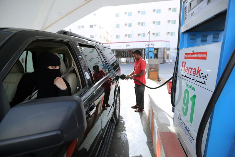 A Saudi woman, Amira, who works in Aramco, refuels her car as she makes her way to her office in Dammam, Saudi Arabia. Hamad I Mohammed / Reuters