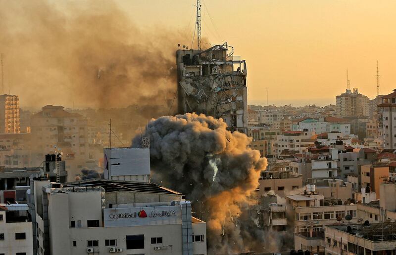 Heavy smoke and fire rise from Al-Sharouk tower as it collapses after being hit by an Israeli air strike, in Gaza City on May 12, 2021. An Israeli air strike destroyed a multi-storey building in Gaza City today, AFP reporters said, as the Jewish state continued its heavy bombardment of the Palestinian enclave. AFP