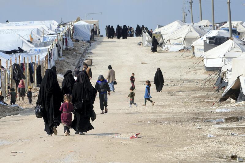 Veiled women, living in al-Hol camp which houses relatives of Islamic State (IS) group members, walk in the camp in al-Hasakeh governorate in northeastern Syria on March 28, 2019. (Photo by GIUSEPPE CACACE / AFP)