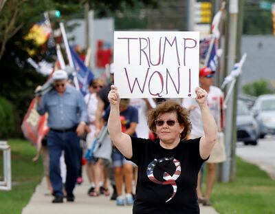 A supporter of former U.S. President Donald Trump wears a QAnon shirt while holding a sign stating he won the 2020 election, outside the North Carolina GOP convention in Greenville, North Carolina, U.S. June 5, 2021.  REUTERS/Jonathan Drake